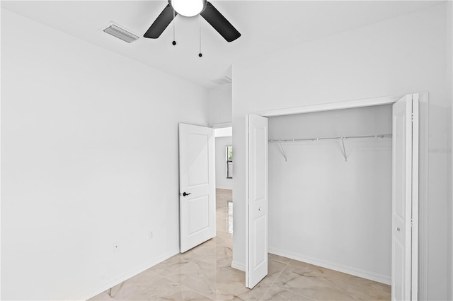 920 Barton St E, Lehigh Acres, FL 33974 - unfurnished bedroom with light marble finish floors, a closet, a ceiling fan, and baseboards