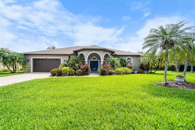 1711 145th St E, Sarasota, FL 34212 - mediterranean / spanish-style house featuring stucco siding, concrete driveway, a garage, and a front lawn