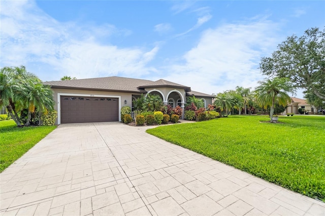 1711 145th St E, Sarasota, FL 34212 - view of front facade with driveway, a front lawn, an attached garage, and stucco siding