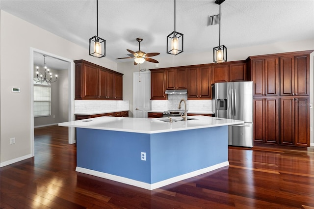 1711 145th St E, Sarasota, FL 34212 - kitchen featuring stainless steel fridge with ice dispenser, under cabinet range hood, dark wood-type flooring, tasteful backsplash, and a textured ceiling