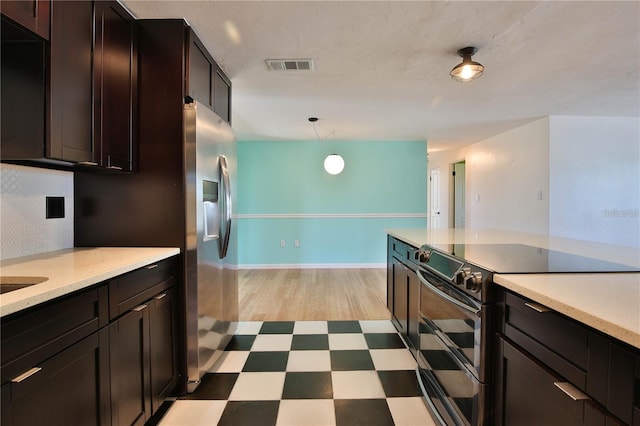 7355 Cass Cir, Sarasota, FL 34231 - kitchen with stainless steel appliances, light floors, light countertops, and dark brown cabinetry