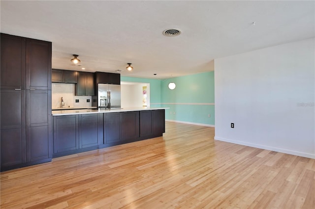 7355 Cass Cir, Sarasota, FL 34231 - kitchen featuring stainless steel fridge with ice dispenser, light countertops, light wood finished floors, and a peninsula