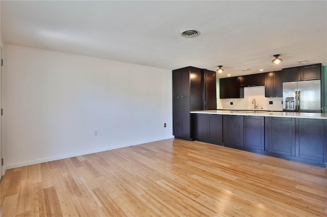 7355 Cass Cir, Sarasota, FL 34231 - kitchen featuring stainless steel fridge, light countertops, and light wood-style flooring