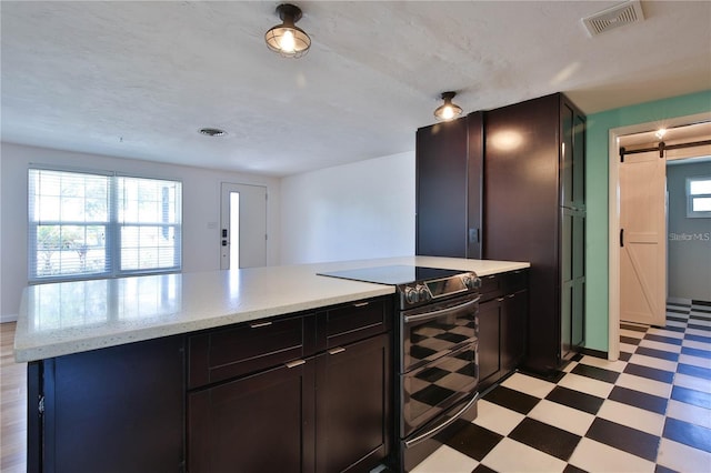7355 Cass Cir, Sarasota, FL 34231 - kitchen featuring range with two ovens, light floors, a barn door, and light stone counters
