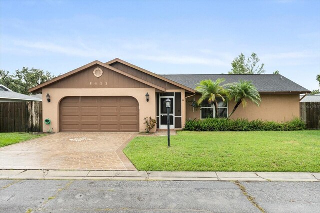 5433 81st Avenue Cir E, Palmetto, FL 34221 - ranch-style house featuring an attached garage, stucco siding, and decorative driveway