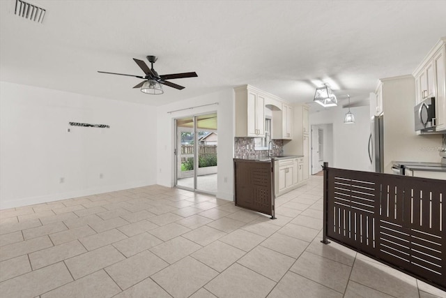 5433 81st Avenue Cir E, Palmetto, FL 34221 - kitchen with stainless steel microwave, light tile patterned flooring, a ceiling fan, electric range, and decorative backsplash