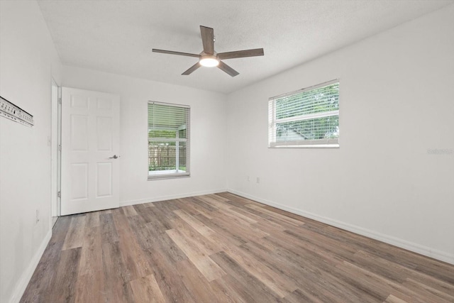 5433 81st Avenue Cir E, Palmetto, FL 34221 - empty room featuring plenty of natural light, wood finished floors, a ceiling fan, and baseboards