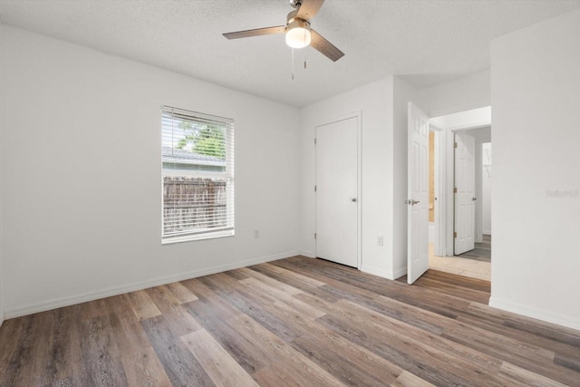 5433 81st Avenue Cir E, Palmetto, FL 34221 - unfurnished bedroom with wood finished floors, baseboards, a textured ceiling, and a ceiling fan