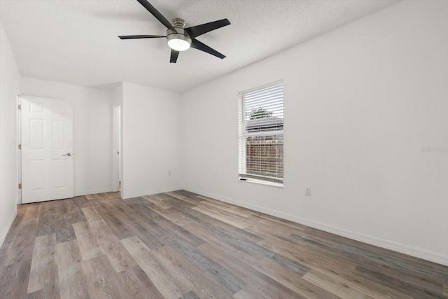 5433 81st Avenue Cir E, Palmetto, FL 34221 - spare room with wood finished floors, ceiling fan, a textured ceiling, and baseboards