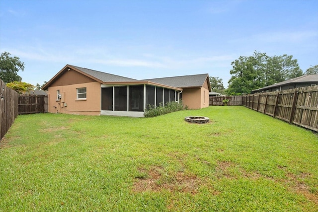 5433 81st Avenue Cir E, Palmetto, FL 34221 - back of house with a fire pit, a sunroom, and stucco siding
