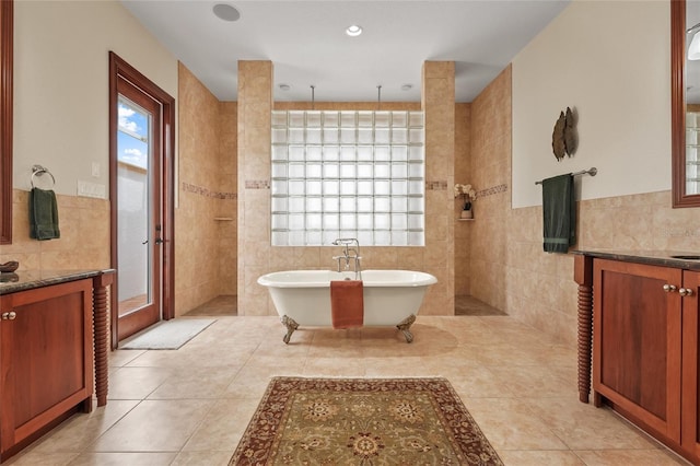 7025 Saddle Creek Cir, Sarasota, FL 34241 - bathroom with tile walls, vanity, a walk in shower, a freestanding tub, and tile patterned floors