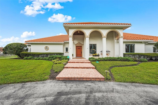 7025 Saddle Creek Cir, Sarasota, FL 34241 - mediterranean / spanish-style home featuring a front lawn, a tile roof, and stucco siding