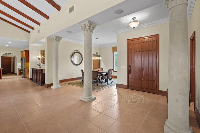 7025 Saddle Creek Cir, Sarasota, FL 34241 - entrance foyer featuring ornate columns, light tile patterned flooring, arched walkways, crown molding, and vaulted ceiling