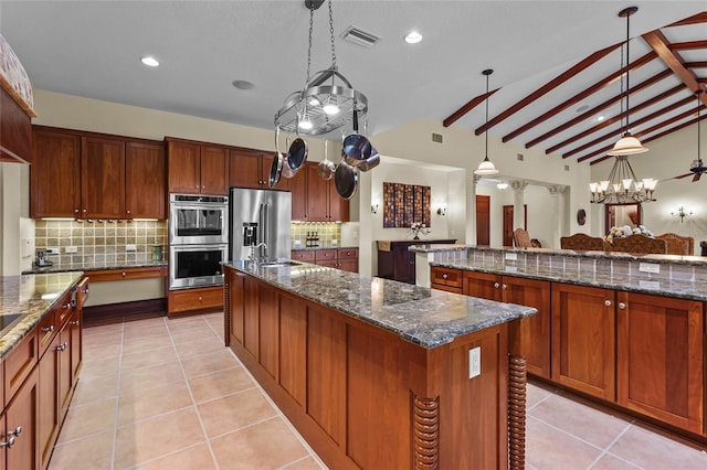 7025 Saddle Creek Cir, Sarasota, FL 34241 - kitchen featuring appliances with stainless steel finishes, a large island, backsplash, dark stone counters, and recessed lighting