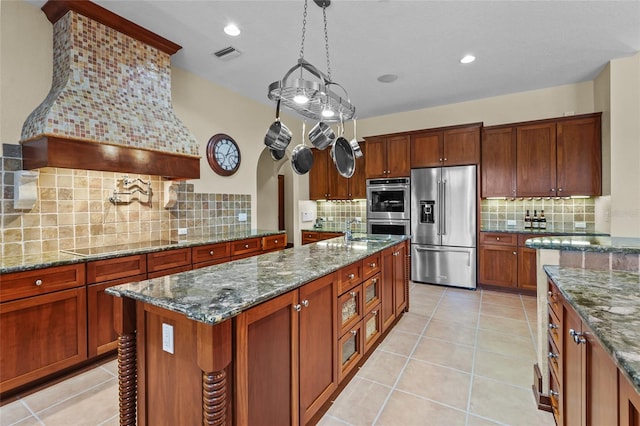 7025 Saddle Creek Cir, Sarasota, FL 34241 - kitchen featuring stainless steel appliances, decorative backsplash, dark stone counters, light tile patterned floors, and recessed lighting