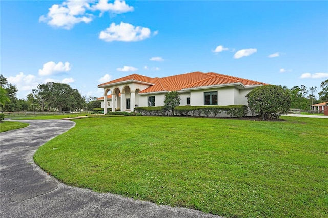 7025 Saddle Creek Cir, Sarasota, FL 34241 - mediterranean / spanish home featuring a tile roof, stucco siding, and a front lawn