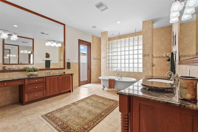 7025 Saddle Creek Cir, Sarasota, FL 34241 - full bathroom with a freestanding bath, double vanity, tile walls, tile patterned floors, and a shower