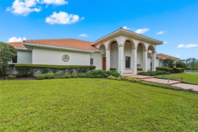 7025 Saddle Creek Cir, Sarasota, FL 34241 - mediterranean / spanish-style house with a tiled roof, stucco siding, and a front lawn