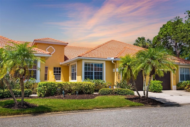 5609 Spanish Point Ct, Palmetto, FL 34221 - mediterranean / spanish-style home with a garage, driveway, a tiled roof, and stucco siding