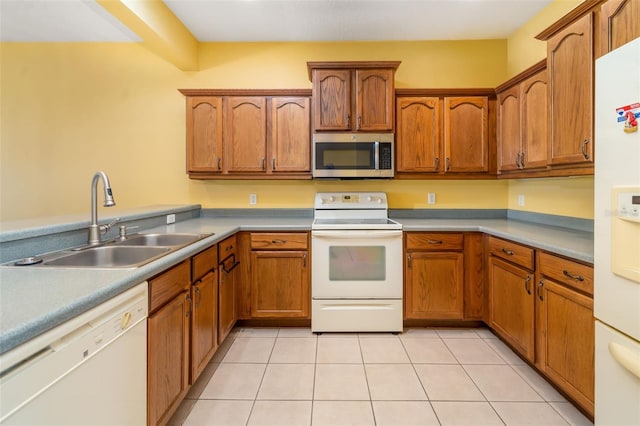 5609 Spanish Point Ct, Palmetto, FL 34221 - kitchen featuring white appliances, a sink, brown cabinetry, light tile patterned floors, and light countertops