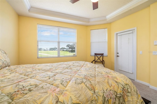 5609 Spanish Point Ct, Palmetto, FL 34221 - carpeted bedroom featuring a tray ceiling, crown molding, a textured ceiling, a ceiling fan, and baseboards