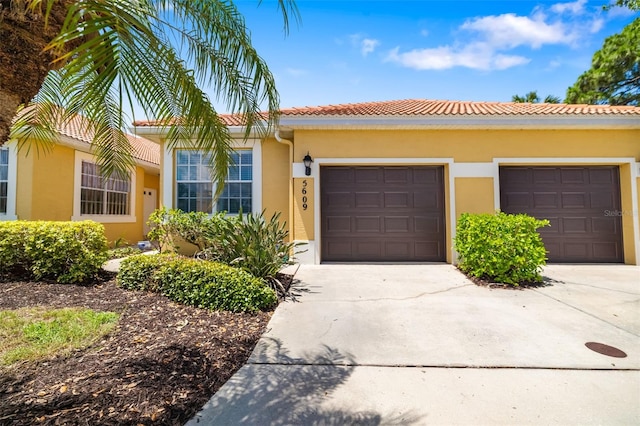 5609 Spanish Point Ct, Palmetto, FL 34221 - view of front of house with stucco siding, an attached garage, concrete driveway, and a tiled roof