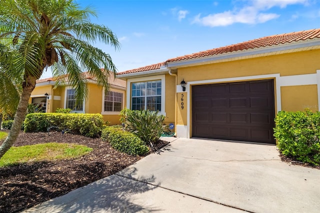 5609 Spanish Point Ct, Palmetto, FL 34221 - mediterranean / spanish home with a garage, stucco siding, driveway, and a tile roof