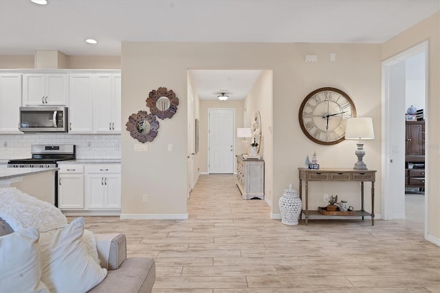 4524 Baltry Ct, Bradenton, FL 34211 - kitchen with appliances with stainless steel finishes, light wood finished floors, white cabinetry, baseboards, and recessed lighting