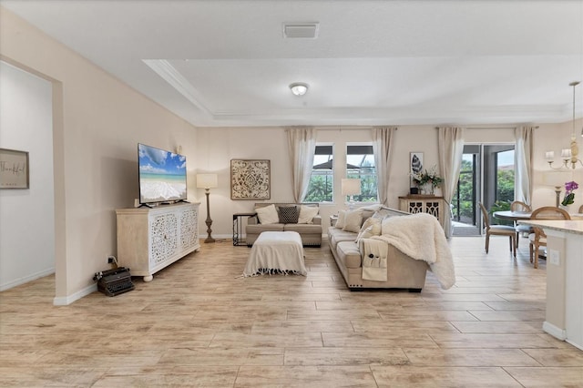 4524 Baltry Ct, Bradenton, FL 34211 - living room with light wood-style flooring, a chandelier, crown molding, baseboards, and a raised ceiling