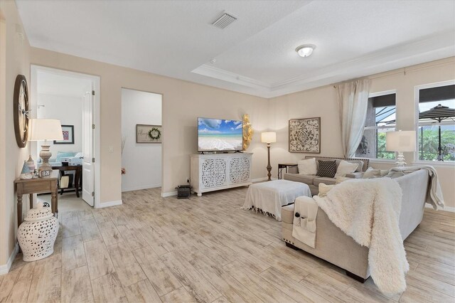 4524 Baltry Ct, Bradenton, FL 34211 - living area with light wood-style floors, baseboards, a raised ceiling, and crown molding