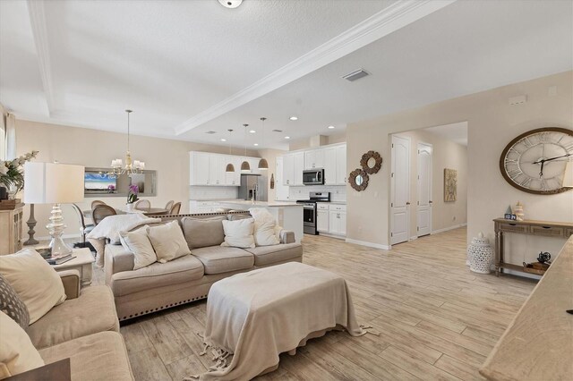 4524 Baltry Ct, Bradenton, FL 34211 - living area with a chandelier, light wood finished floors, crown molding, a raised ceiling, and baseboards