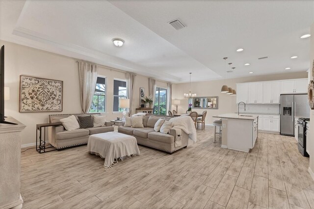 4524 Baltry Ct, Bradenton, FL 34211 - living room featuring light wood finished floors, a chandelier, baseboards, and recessed lighting
