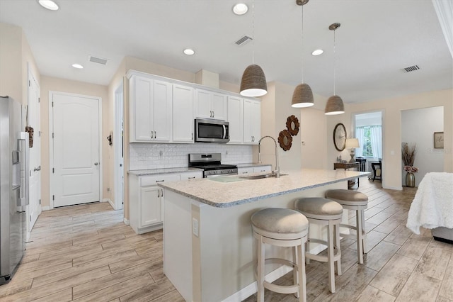 4524 Baltry Ct, Bradenton, FL 34211 - kitchen with appliances with stainless steel finishes, light wood-type flooring, light countertops, a kitchen bar, and backsplash