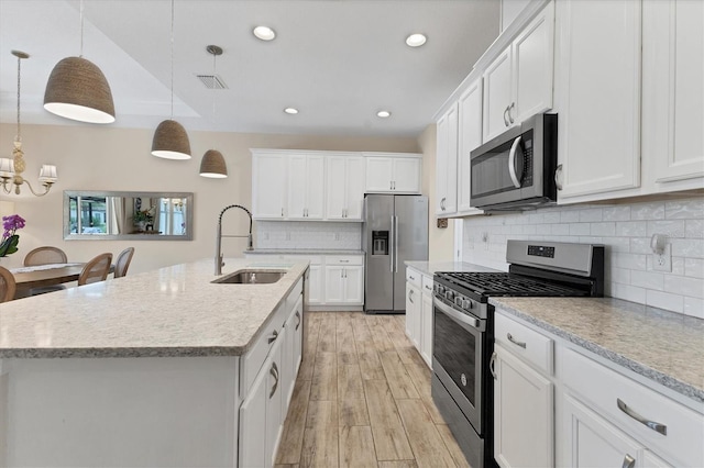 4524 Baltry Ct, Bradenton, FL 34211 - kitchen with appliances with stainless steel finishes, a sink, white cabinetry, a kitchen island with sink, and recessed lighting