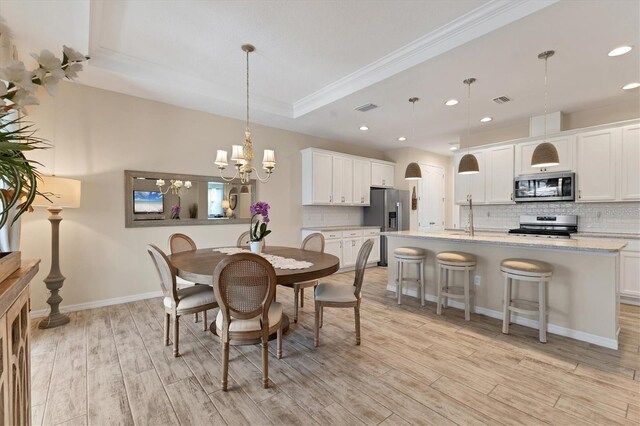 4524 Baltry Ct, Bradenton, FL 34211 - dining space with a chandelier, light wood finished floors, ornamental molding, recessed lighting, and a raised ceiling