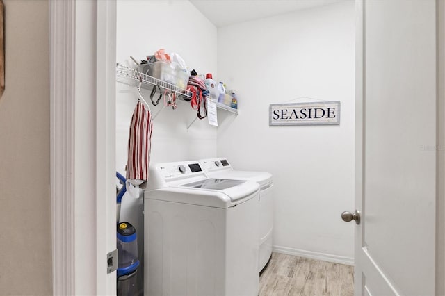 4524 Baltry Ct, Bradenton, FL 34211 - laundry area featuring washer and dryer, light wood-style floors, and baseboards