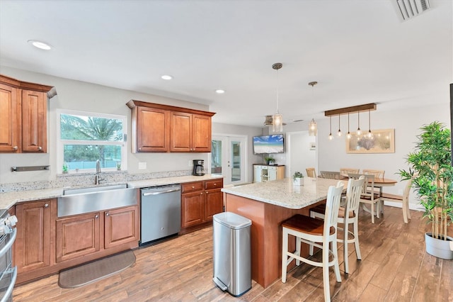7727 9th Avenue Dr NW, Bradenton, FL 34209 - kitchen with appliances with stainless steel finishes, a sink, light wood finished floors, brown cabinetry, and recessed lighting