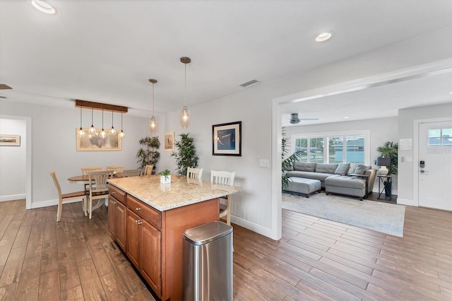 7727 9th Avenue Dr NW, Bradenton, FL 34209 - kitchen featuring brown cabinetry, ceiling fan, wood-type flooring, a center island, and recessed lighting