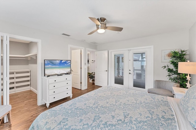 7727 9th Avenue Dr NW, Bradenton, FL 34209 - bedroom featuring french doors, wood finished floors, access to exterior, ceiling fan, and a walk in closet
