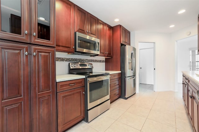 7401 3rd Ave NW, Bradenton, FL 34209 - kitchen with appliances with stainless steel finishes, light countertops, light tile patterned floors, recessed lighting, and dark brown cabinets