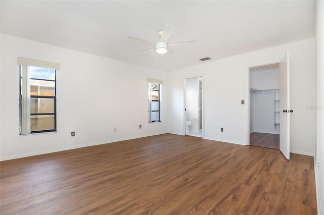 7401 3rd Ave NW, Bradenton, FL 34209 - unfurnished bedroom featuring dark wood-style floors, connected bathroom, ceiling fan, and a spacious closet