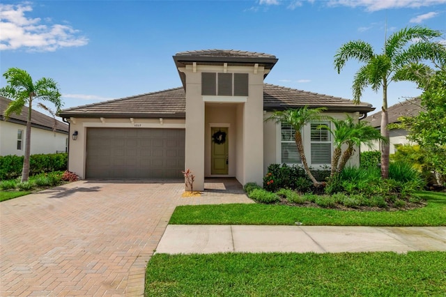 4869 Antrim Dr, Sarasota, FL 34240 - view of front of house featuring an attached garage, decorative driveway, stucco siding, and a tiled roof