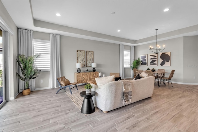 4869 Antrim Dr, Sarasota, FL 34240 - living room with a chandelier, baseboards, a raised ceiling, light wood-style floors, and recessed lighting