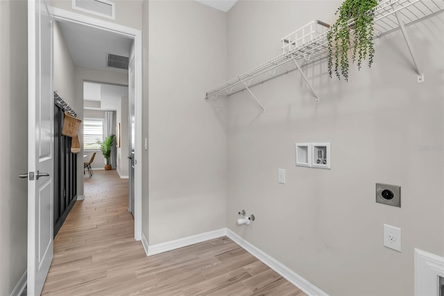 4869 Antrim Dr, Sarasota, FL 34240 - laundry area featuring hookup for an electric dryer, hookup for a washing machine, baseboards, and light wood-style flooring