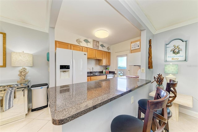 767 John Ringling Blvd Unit 25, Sarasota, FL 34236 - kitchen with white refrigerator with ice dispenser, a sink, light tile patterned floors, crown molding, and a breakfast bar