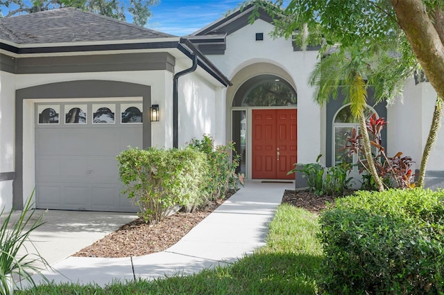 5103 Twin Creeks Dr, Valrico, FL 33596 - doorway to property featuring an attached garage, stucco siding, driveway, and a shingled roof
