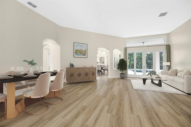 5103 Twin Creeks Dr, Valrico, FL 33596 - living room with arched walkways, light wood-style floors, and french doors
