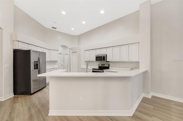 5103 Twin Creeks Dr, Valrico, FL 33596 - kitchen with appliances with stainless steel finishes, light wood-type flooring, arched walkways, light countertops, and a towering ceiling