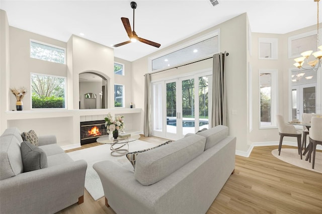 5103 Twin Creeks Dr, Valrico, FL 33596 - living area with a chandelier, light wood finished floors, a tile fireplace, ceiling fan, and recessed lighting