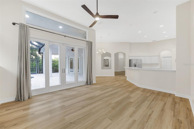 5103 Twin Creeks Dr, Valrico, FL 33596 - unfurnished living room with a ceiling fan, light wood finished floors, a chandelier, arched walkways, and recessed lighting